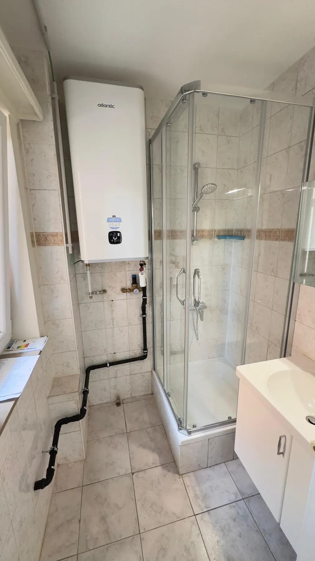 Douche et chauffe-eau raccordés dans une salle de bain