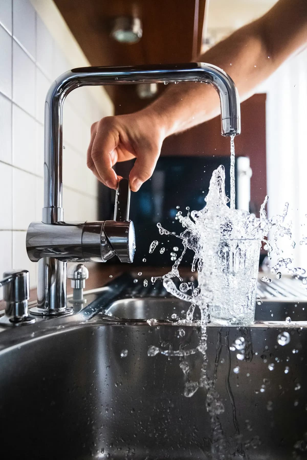 Verre rempli d'eau au robinet d'une cuisine