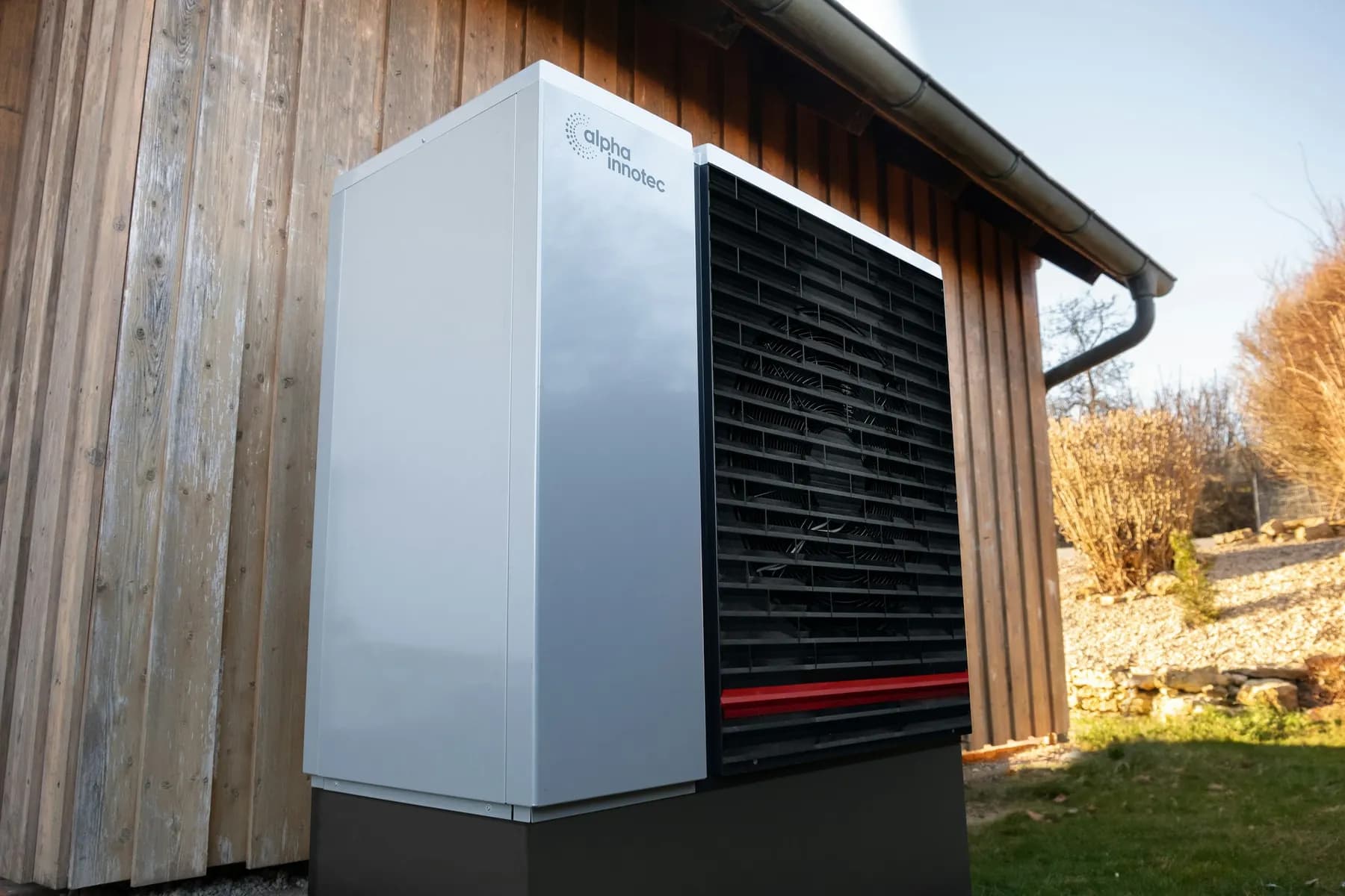 Pompe à chaleur air-eau posée contre un bardage en bois