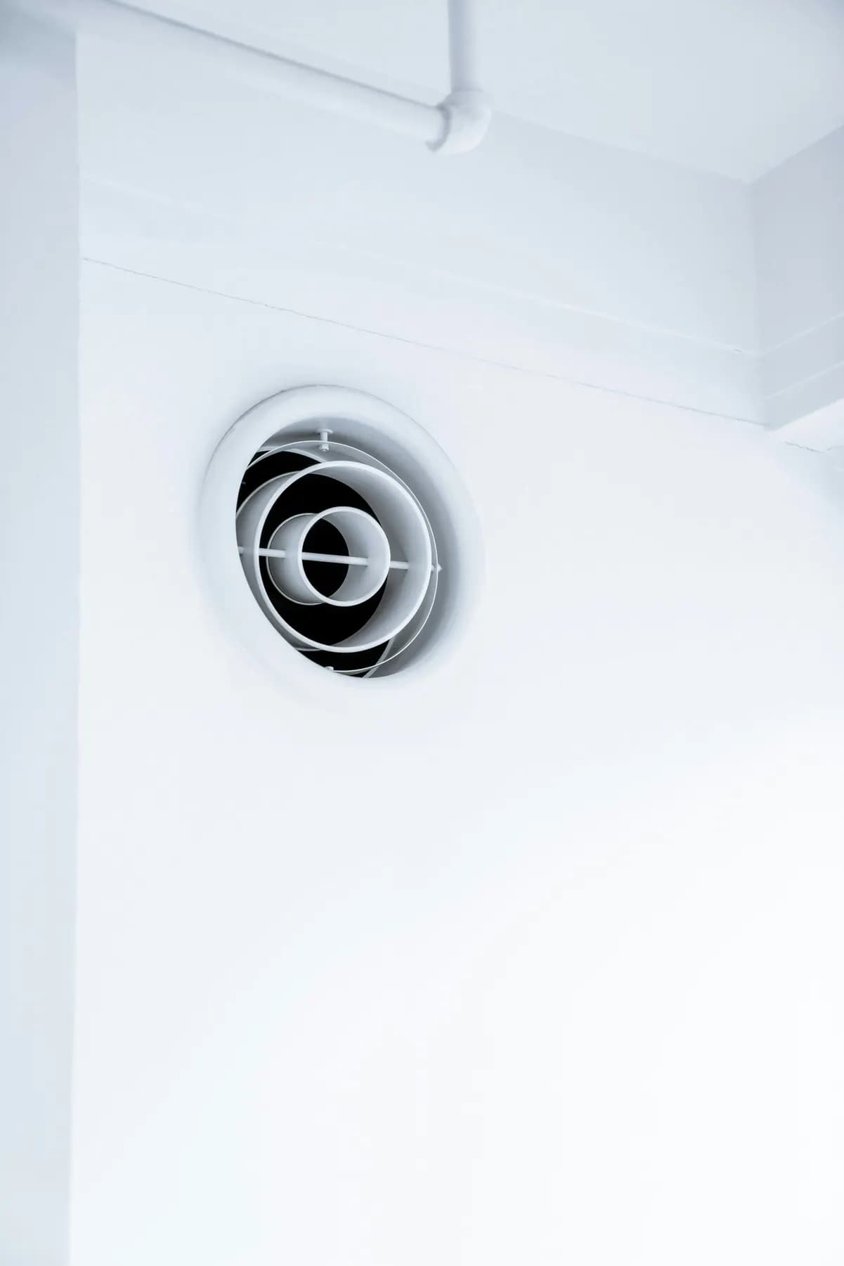 Bouche de ventilation ronde dans un mur blanc